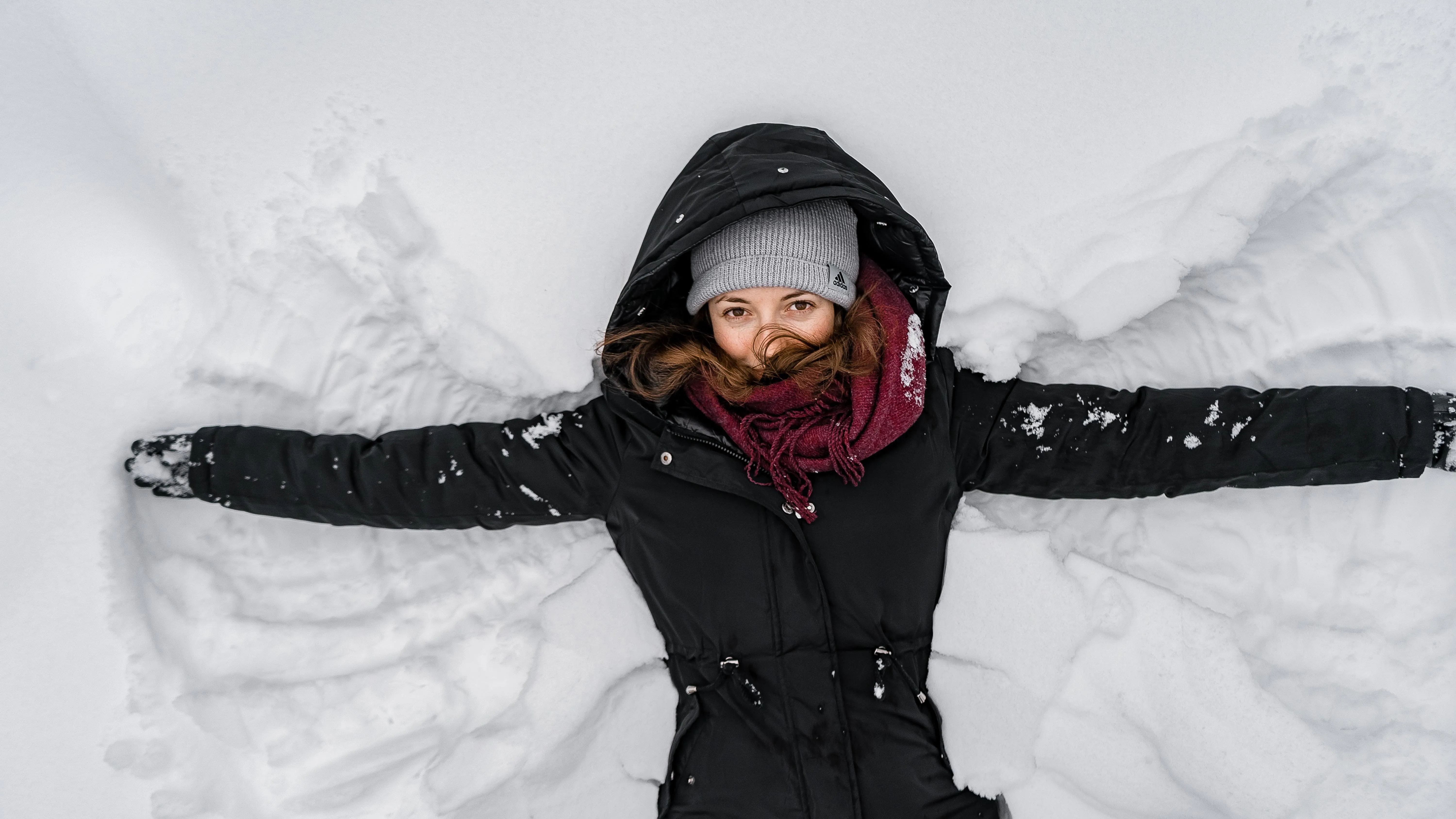 Frau liegt im Schnee