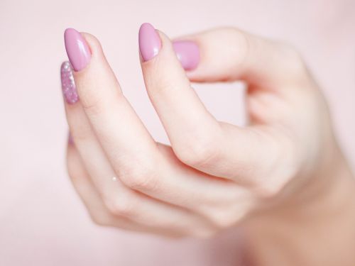 Hand mit Rosa lackierten Nägeln