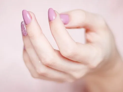 Hand mit Rosa lackierten Nägeln