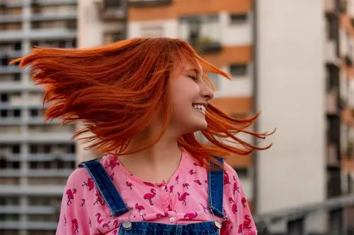 Frau mit roten Haaren die durch die Luft fliegen