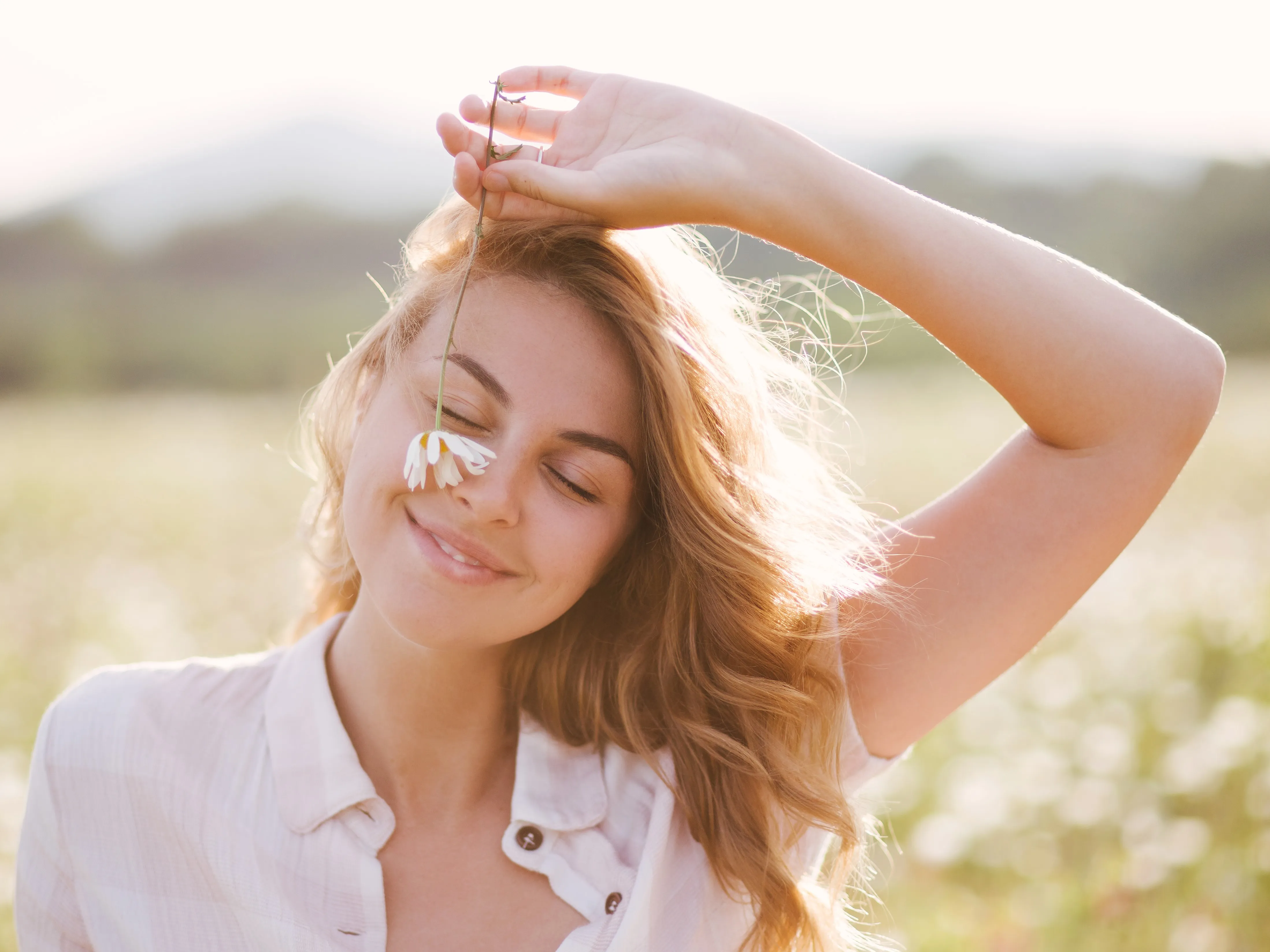 Frau im Feld mit Blume in der Hand