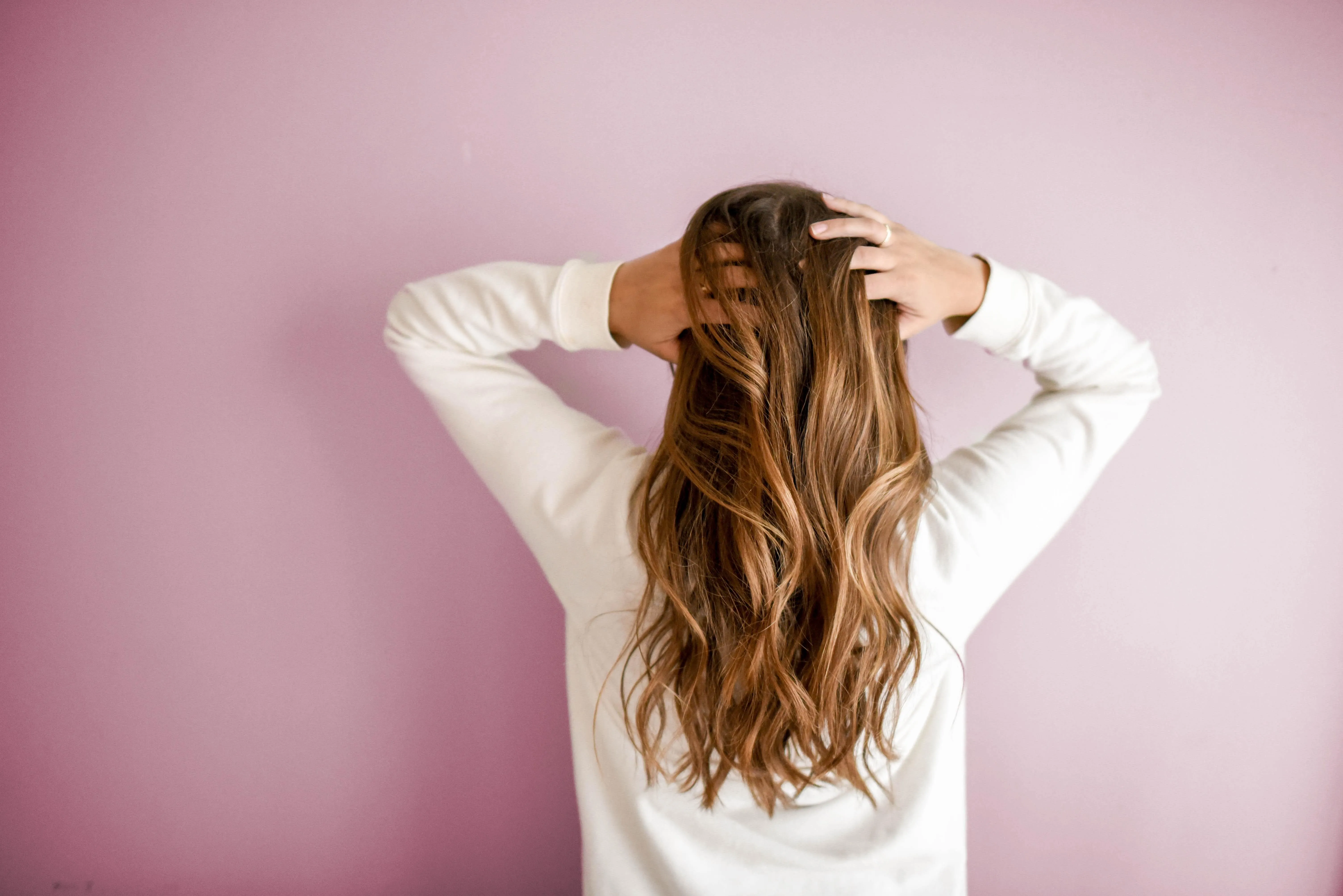 Frau von hinten die sich in die Haare greift