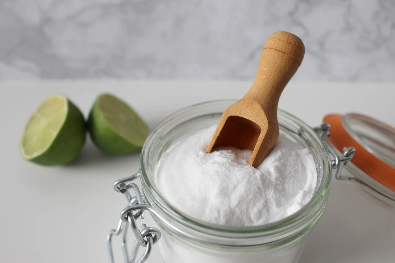Glasschüssel mit Natron, Portionierer und Limetten