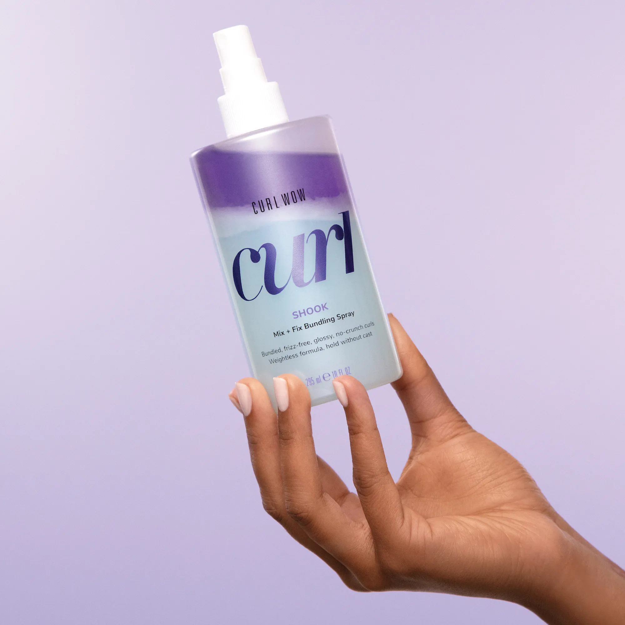 Frau hält Curl Wow Shook Mix + Fix Bundling Spray von Color Wow in der Hand
