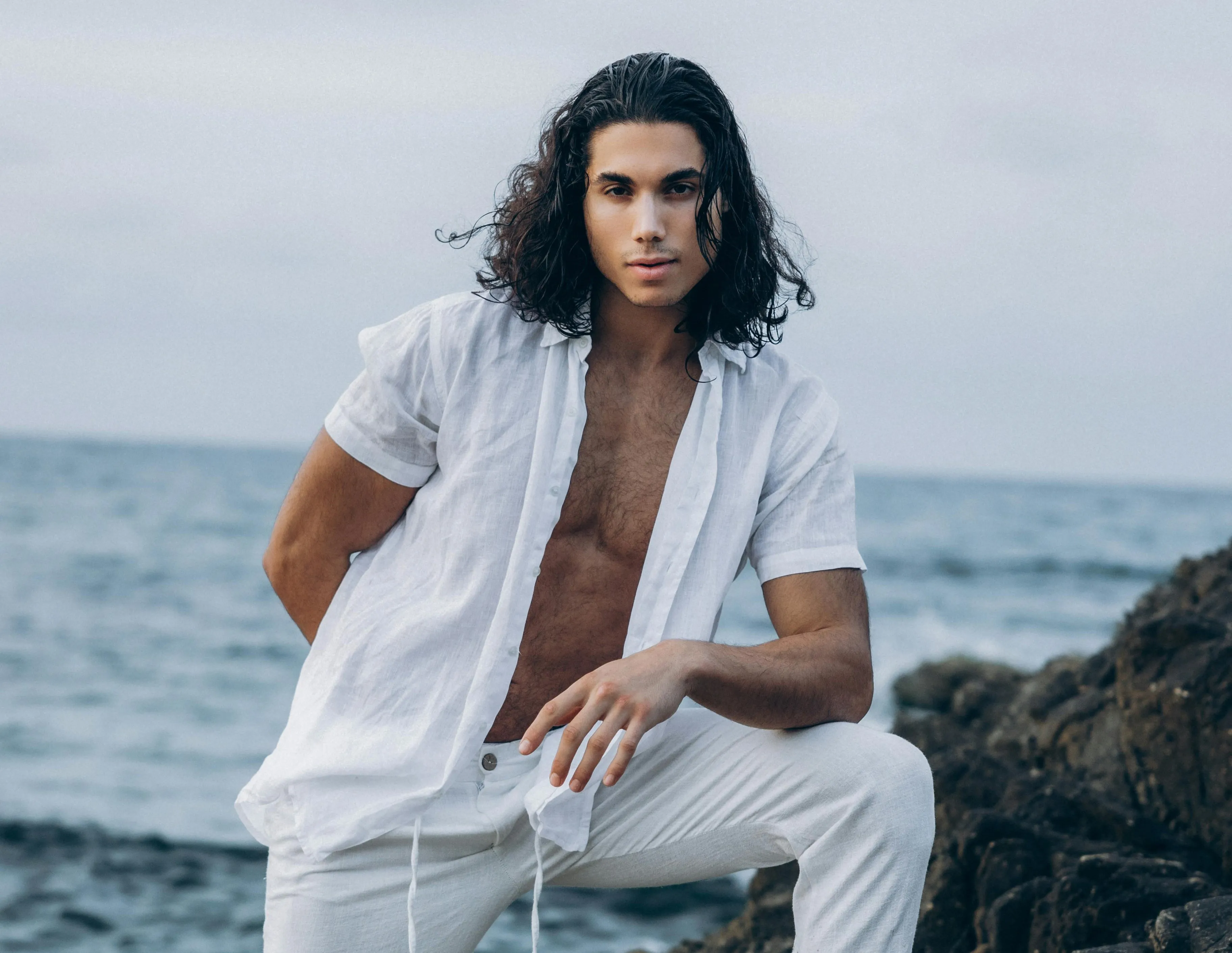 Mann am Strand mit Sleek Back Frisur mit langen Haaren