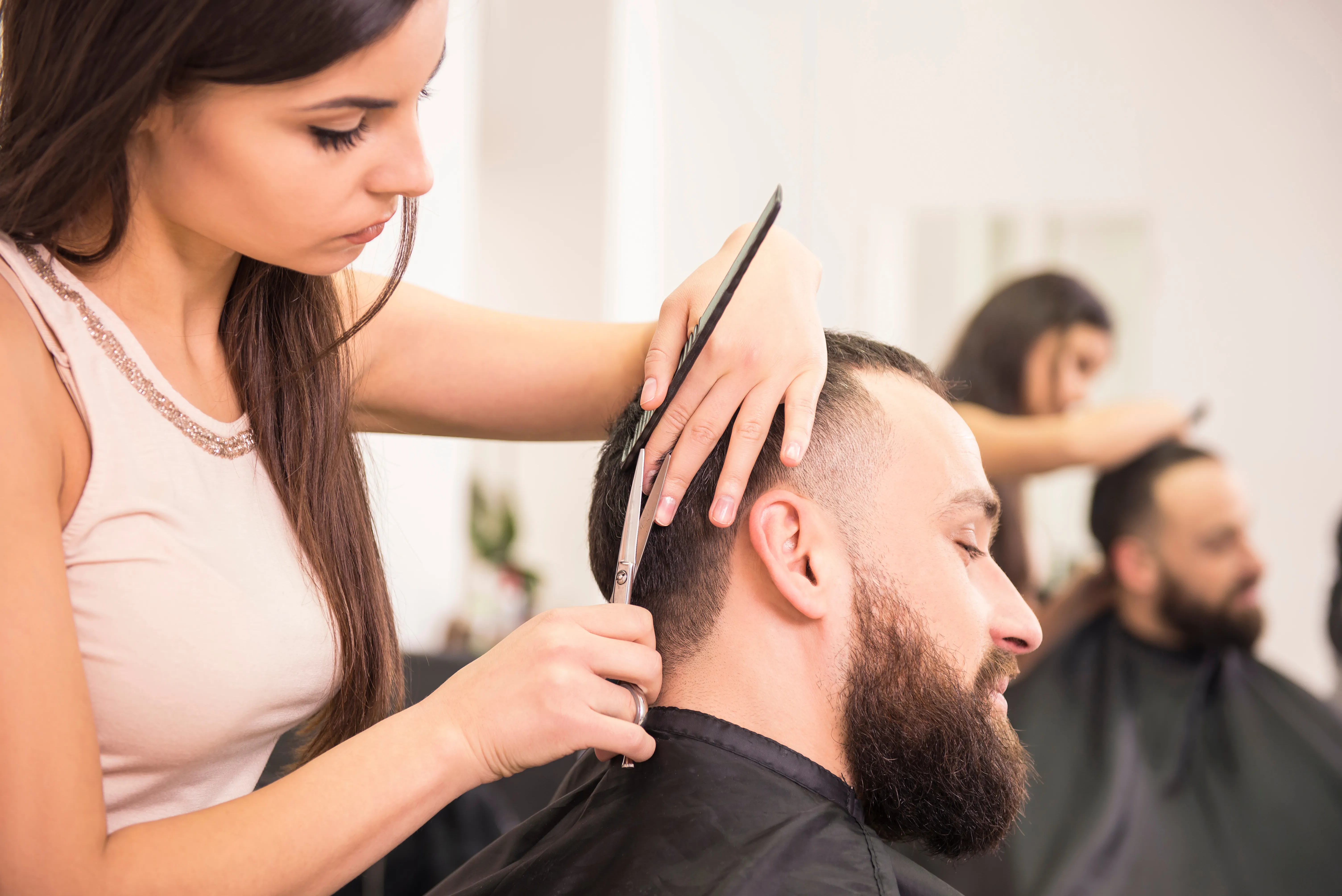 Friseurin schneidet Mann Buzz Cut