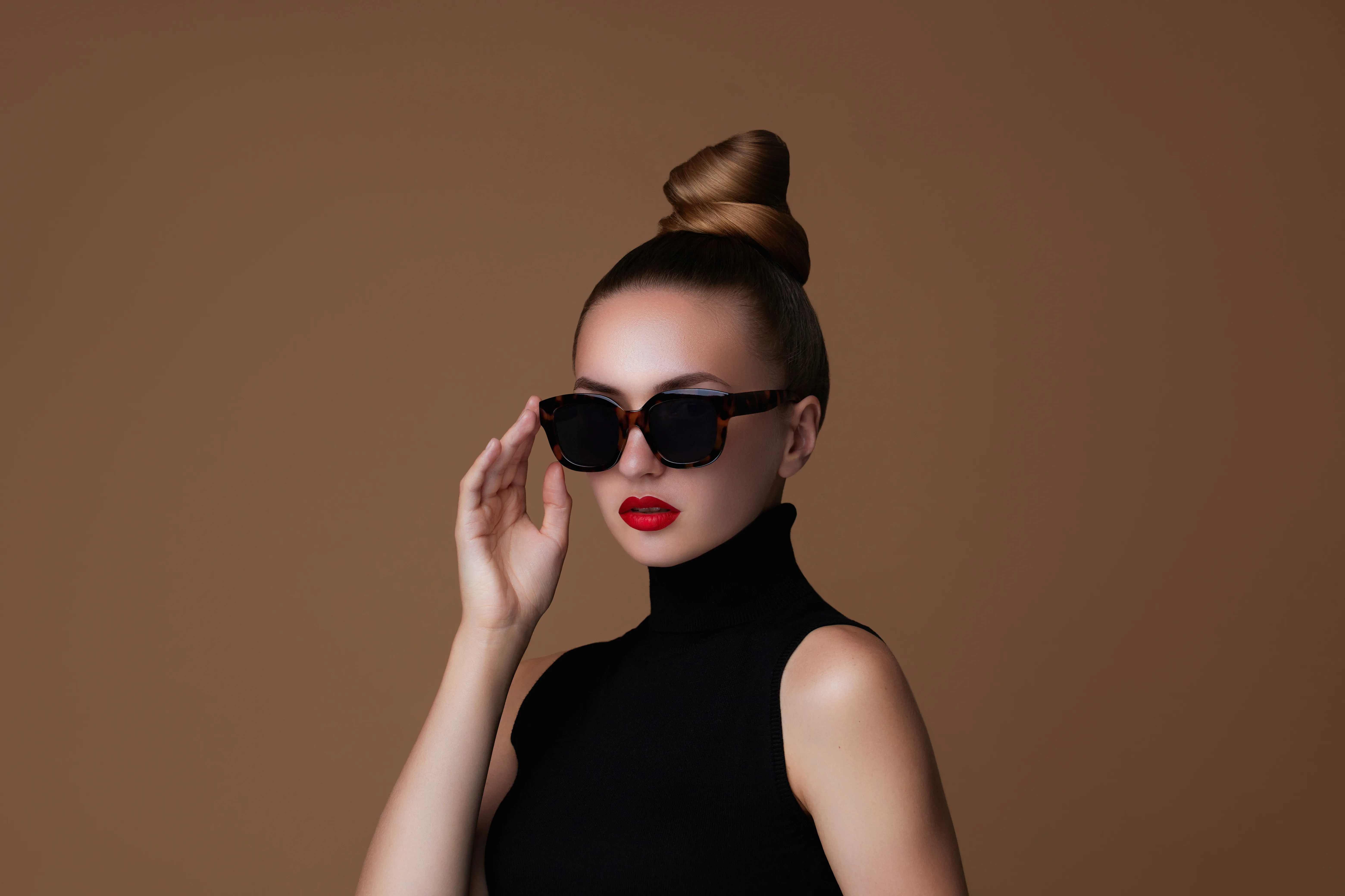 Frau mit hohem Sleek Bund und dunkler Sonnenbrille