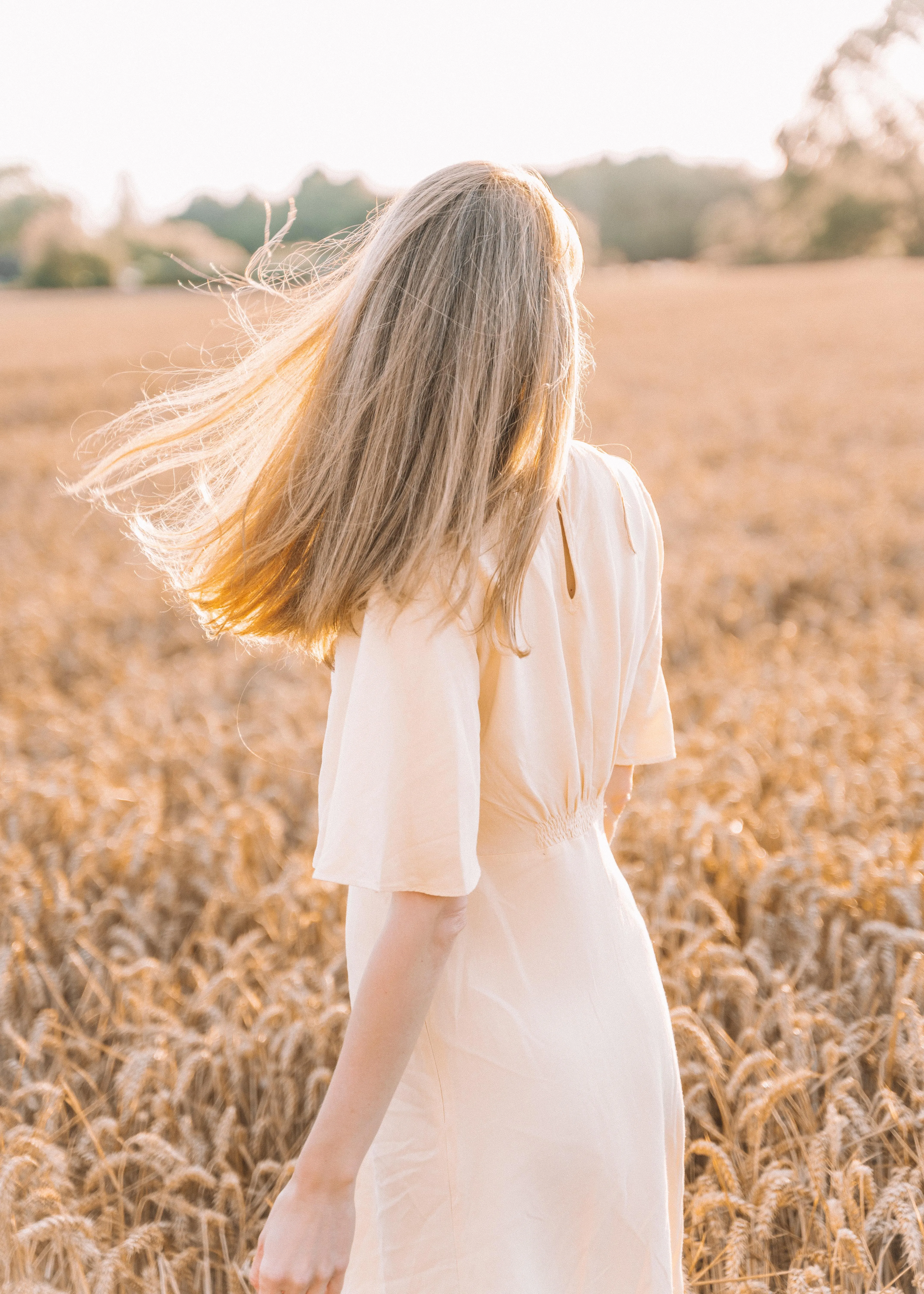 Blonde Frau im Kleid in Kornfeld