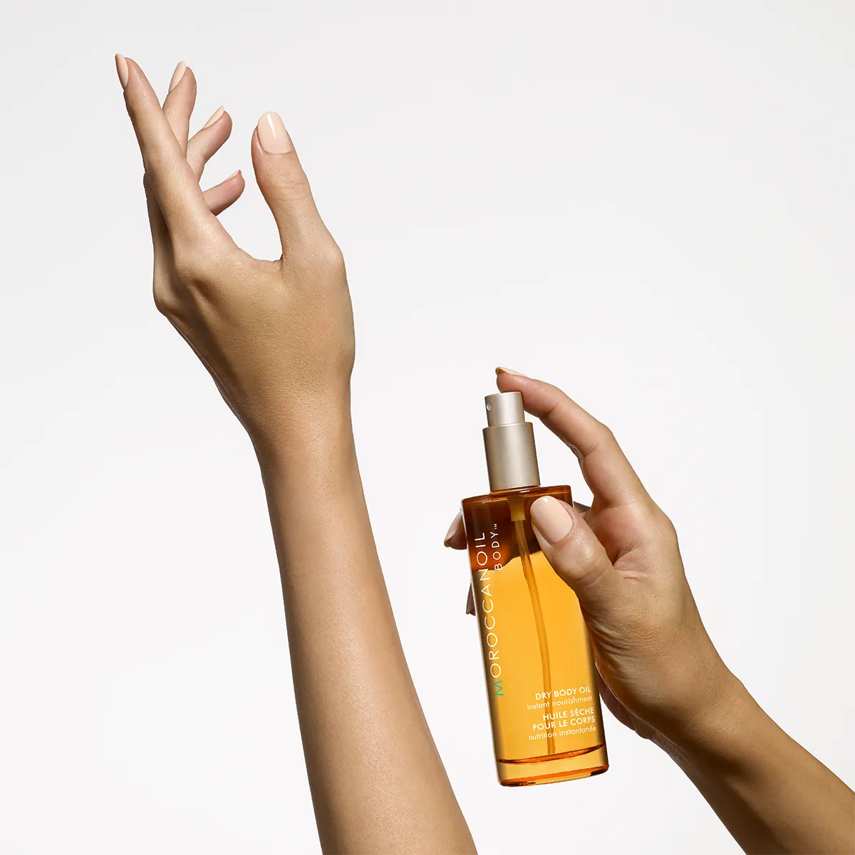 Frau sprüht Moroccanoil Fragrance auf ihr Handgelenk