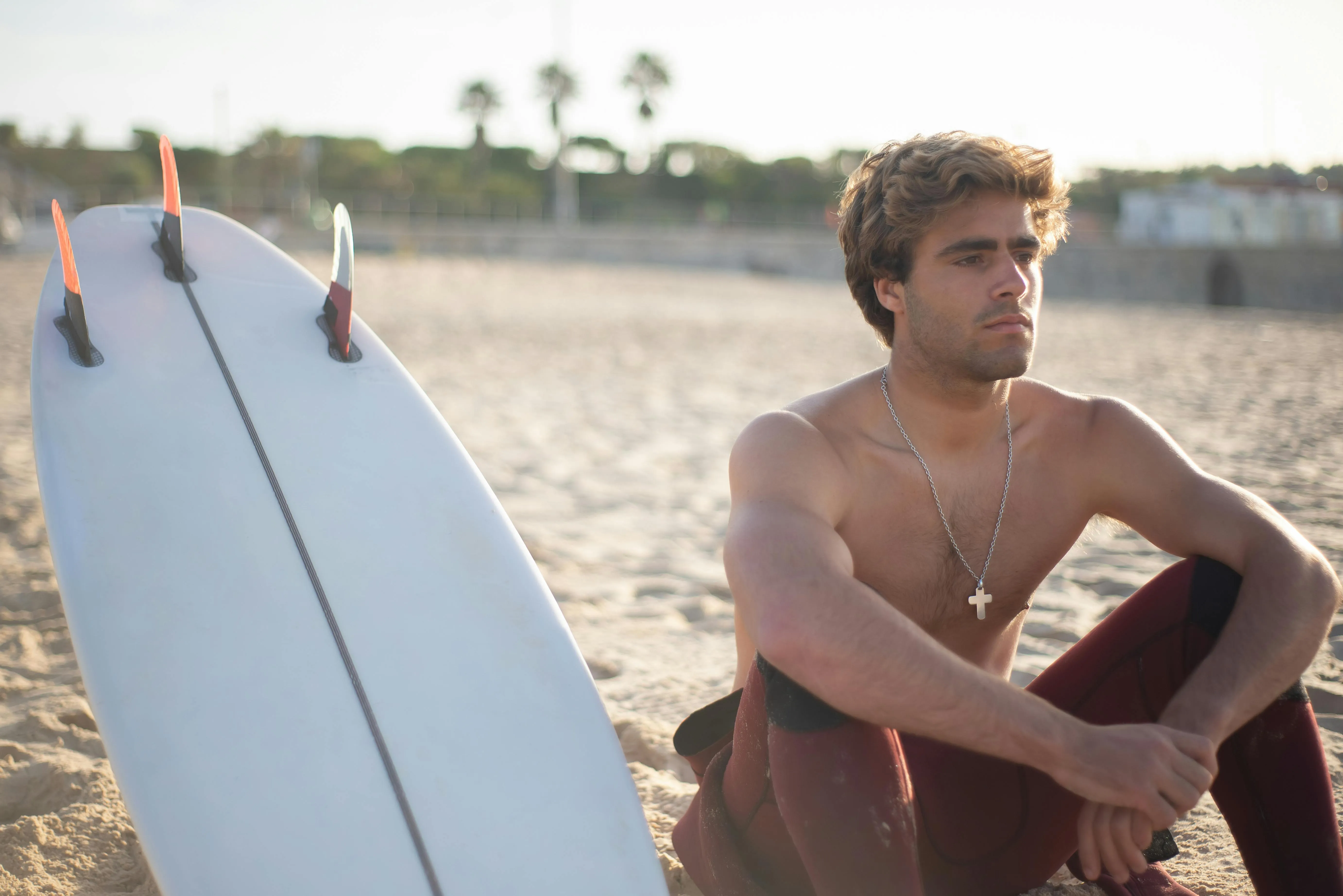 Mann mit Surfbrett am Strand