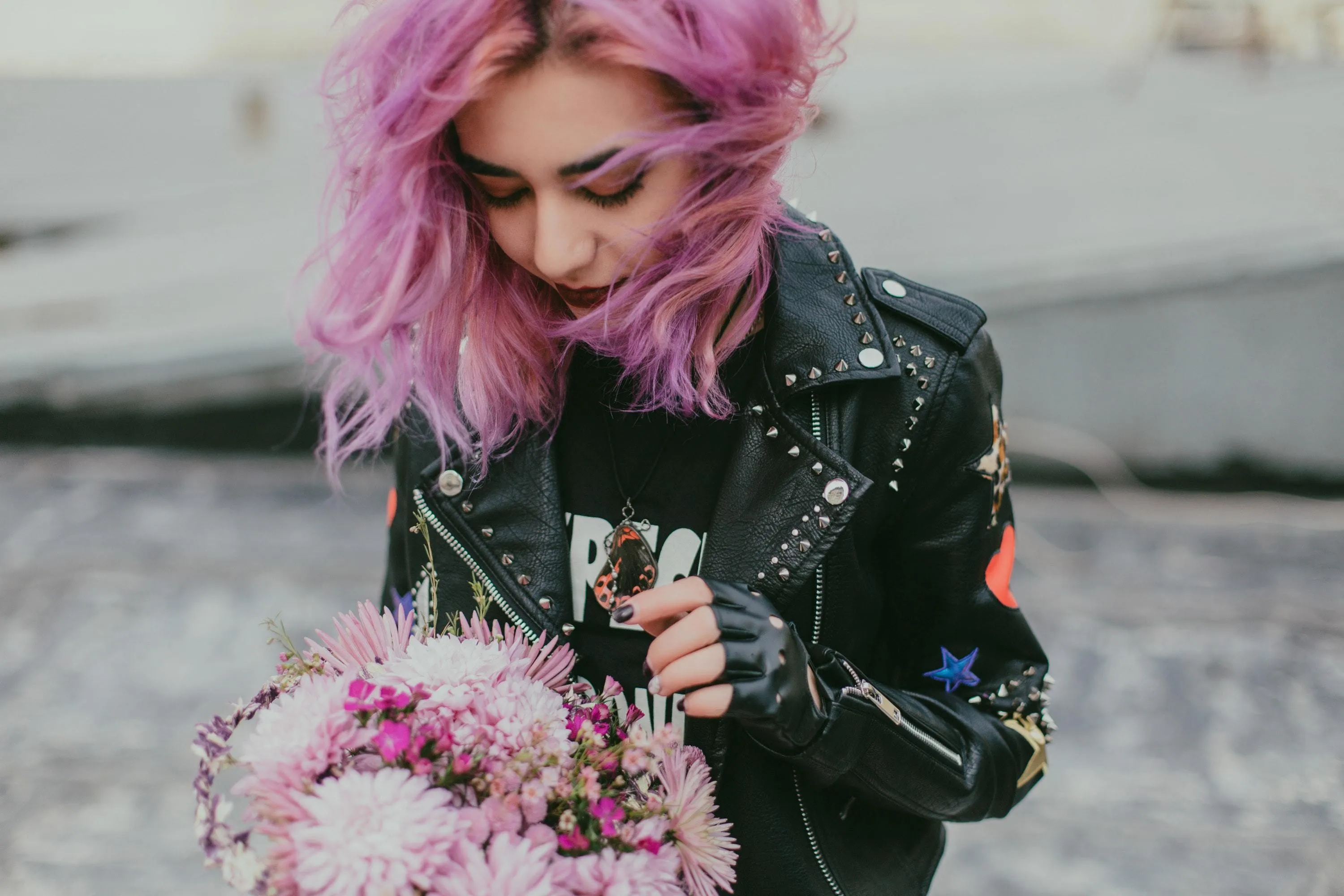 Frau mit pinken Haaren und Blumen in der Hand
