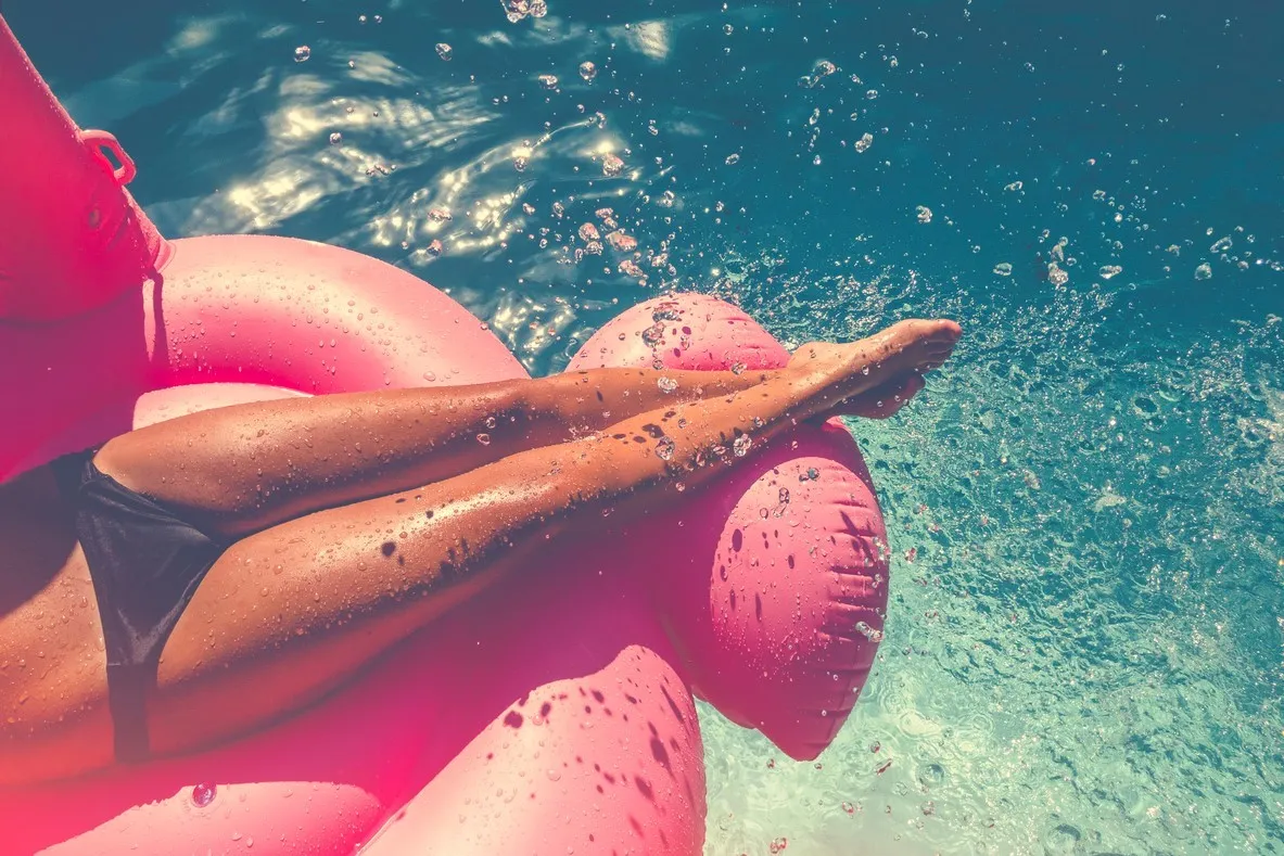 Frau auf Luftmatratze im Wasser