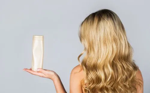 Dame mit Haarflasche in der Hand